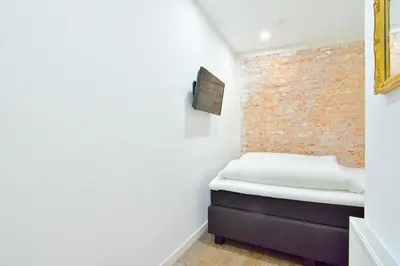a small bedroom with a brick wall at Hotel La Belle Vue in Amsterdam