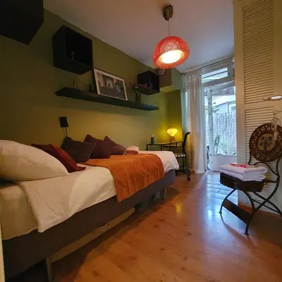 a bedroom with a bed with an orange blanket at Zoet Amsterdam in Amsterdam