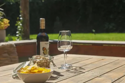 a bottle of wine and a bowl of chips and a wine glass at Juneberry Ecolodge Bergen in Bergen