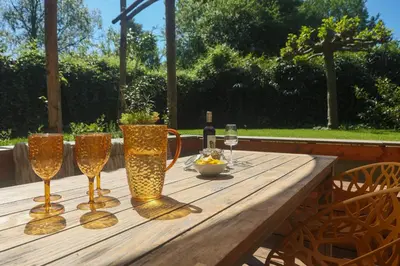 a wooden table with glasses and a bottle of wine at Juneberry Ecolodge Bergen in Bergen