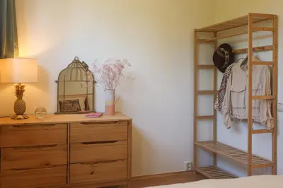 a bedroom with a dresser and a bird cage on a shelf at Juneberry Ecolodge Bergen in Bergen
