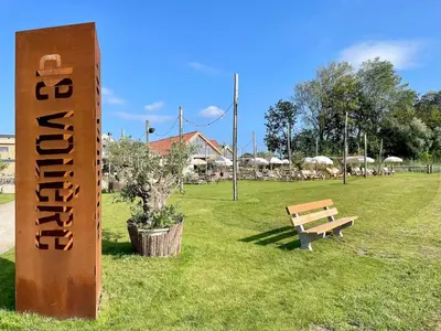 a sign in a park with a bench in the grass at Holiday home close to beach and Keukenhof in Noordwijkerhout