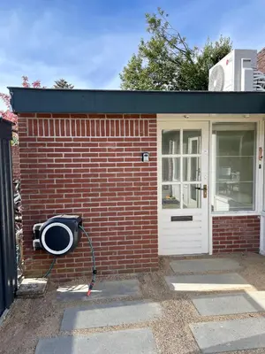 a small brick building with a door and a pan at Holiday home close to beach and Keukenhof in Noordwijkerhout