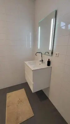 a white bathroom with a sink and a mirror at B&B Kopwest 1 in Purmerend