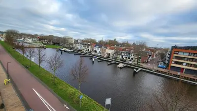 a river with a bridge in a city with buildings at B&B Kopwest 1 in Purmerend