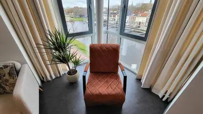 a chair sitting in front of a large window at B&B Kopwest 2 in Purmerend
