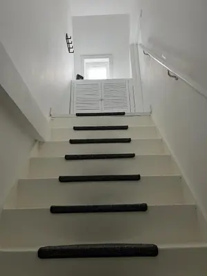 a staircase with black carpeting and a window at Cozy 2 bedroom apartment in Maarssen
