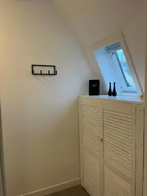 a room with a window and a cabinet with vases on it at Cozy 2 bedroom apartment in Maarssen