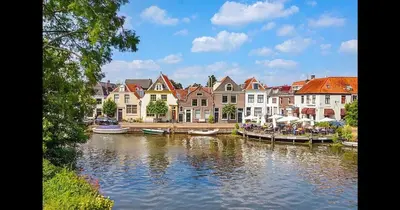 a group of houses and boats on a river at Cozy 2 bedroom apartment in Maarssen