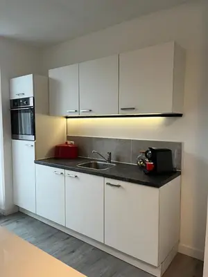 a kitchen with white cabinets and a sink at Cozy 2 bedroom apartment in Maarssen