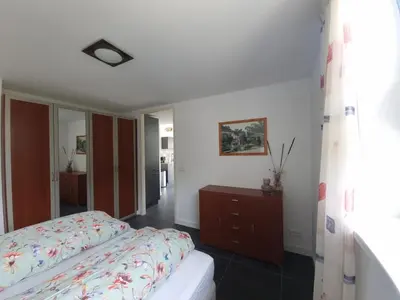a bedroom with a bed and a dresser in it at De bloemenkwekerij in Egmond-Binnen