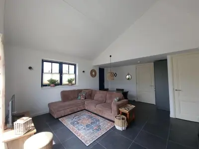 a living room with a couch and a rug at De bloemenkwekerij in Egmond-Binnen
