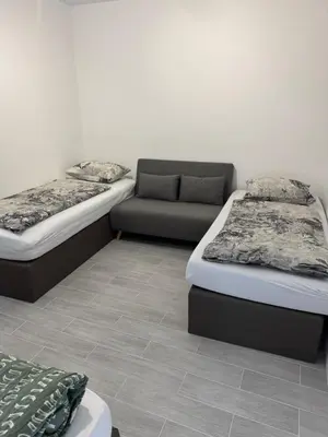 two beds and a couch in a room at Smile home 3 Wormerveer- Zaanse Schans en Amsterdam appartements in Wormerveer