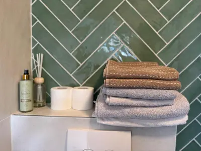 a stack of towels on a counter in a bathroom at Smile home 3 Wormerveer- Zaanse Schans en Amsterdam appartements in Wormerveer
