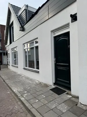 a white house with a black door on a street at Smile home 3 Wormerveer- Zaanse Schans en Amsterdam appartements in Wormerveer