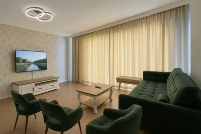 a living room with a couch and chairs and a tv at Reza Almere in Almere
