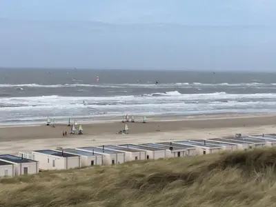 a beach with a bunch of buildings and the ocean at Almost At The Beach in Wijk aan Zee