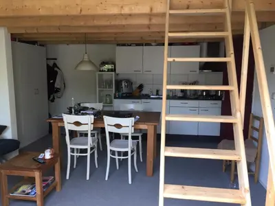 a loft bed in a kitchen with a table and chairs at Almost At The Beach in Wijk aan Zee