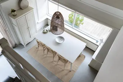 a white table and chairs in a room with a window at -Casa Como- nabij het meer, restaurants & keukenhof in Noordwijkerhout