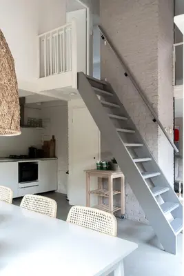 a white staircase in a kitchen with a table and chairs at -Casa Como- nabij het meer, restaurants & keukenhof in Noordwijkerhout