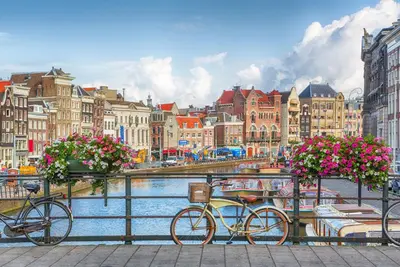 two bikes parked next to a river with buildings at Reumann Holiday Apartments De Schelp 12 in Zandvoort