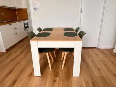 a dining room table with chairs and a kitchen at Reumann Holiday Apartments De Schelp 12 in Zandvoort