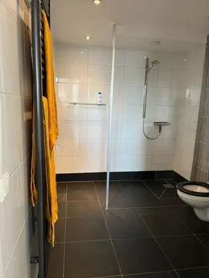 a bathroom with a shower and a toilet at Appartement aan het water in Alkmaar