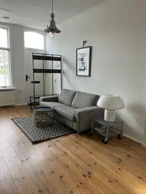 a living room with a couch and a table at Appartement aan het water in Alkmaar