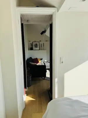 a bedroom with a door open to a living room at BeachHouse Oranje Nassau in Noordwijk aan Zee