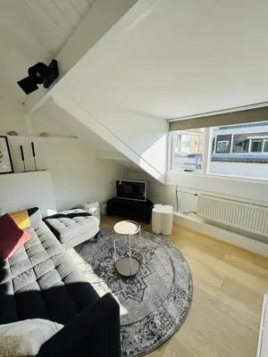 a living room with a couch and a table at BeachHouse Oranje Nassau in Noordwijk aan Zee