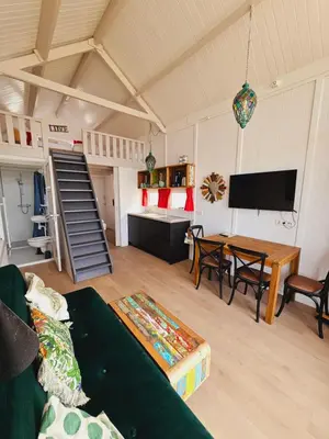 a living room with a couch and a table at Strandvakantiehuisjes Katwijk in Katwijk aan Zee