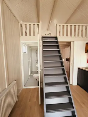 a staircase in a tiny house with a bathroom at Strandvakantiehuisjes Katwijk in Katwijk aan Zee