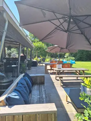 a group of picnic tables with an umbrella at Rekerlanden 211 in Schoorldam