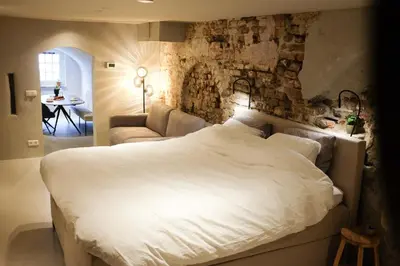 a bedroom with a large white bed and a couch at Domnacht aan de gracht in Utrecht
