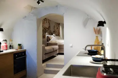 a kitchen with a sink and a living room at Domnacht aan de gracht in Utrecht