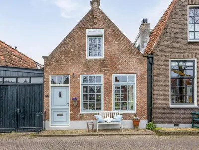 a brick house with a white door and windows at Boutique Canal house 't Jannetje - historical and cozy in Edam