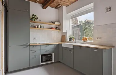 a kitchen with gray cabinets and a window at Boutique Canal house 't Jannetje - historical and cozy in Edam
