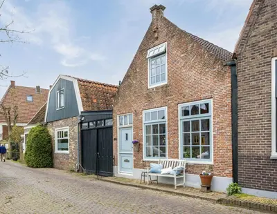 a brick house with a blue door and windows at Boutique Canal house 't Jannetje - historical and cozy in Edam