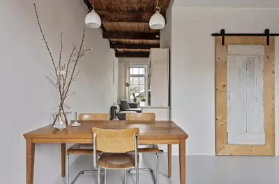 a dining room with a wooden table and chairs at Boutique Canal house 't Jannetje - historical and cozy in Edam