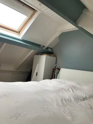 a bedroom with a white bed and a window at Nice and cosy house close Amsterdam and airport in Badhoevedorp