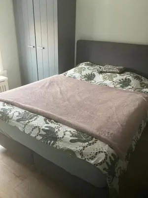 a bed with a pink blanket on top of it at Nice and cosy house close Amsterdam and airport in Badhoevedorp