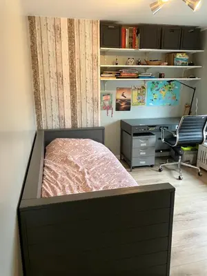 a bedroom with a bed and a desk and a computer at Nice and cosy house close Amsterdam and airport in Badhoevedorp
