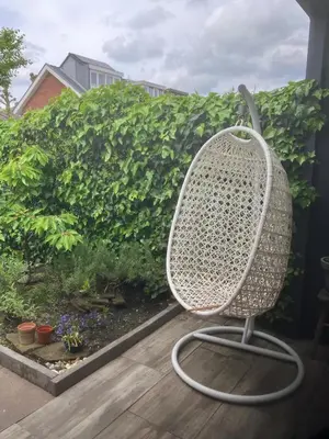 a white chair sitting on a porch with a garden at Nice and cosy house close Amsterdam and airport in Badhoevedorp