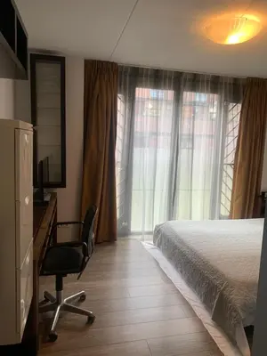 a bedroom with a bed and a desk and a chair at Lounge Park Apartment in Amsterdam