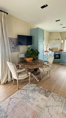 a living room with a table and chairs and a kitchen at De Lindenhof in Tienhoven