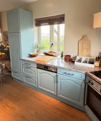 a kitchen with blue cabinets and a counter top at De Lindenhof in Tienhoven