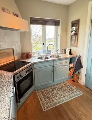 a kitchen with two sinks and a window at De Lindenhof in Tienhoven