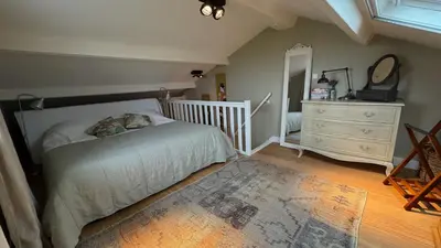 a bedroom with a bed and a dresser and a mirror at De Lindenhof in Tienhoven