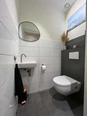 a bathroom with a toilet and a sink and a mirror at Rhynhoven Lodge in Hazerswoude-Rijndijk
