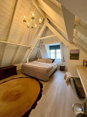 a bedroom with a large bed in an attic at Rhynhoven Lodge in Hazerswoude-Rijndijk